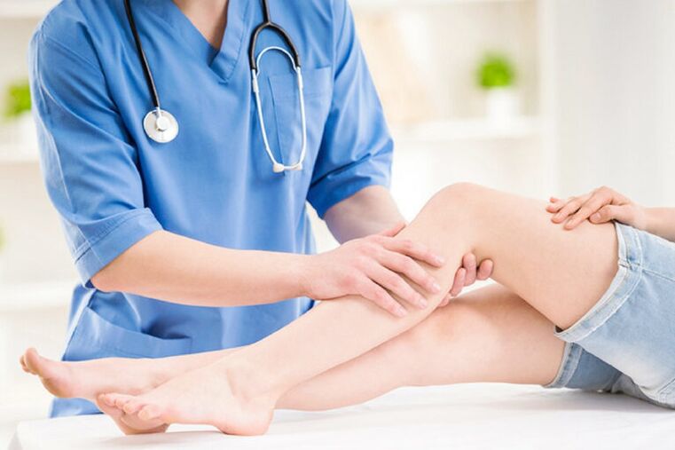 the doctor examines the legs with varicose veins